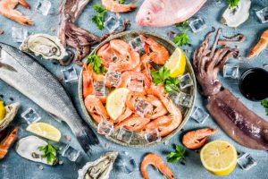 fresh-raw-seafood-squid-shrimp-oyster-mussels-fish-with-spices-herbs-lemon-light-blue-background_136595-8274
